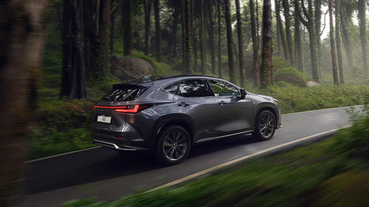 A Lexus NX rijdend door een bos 